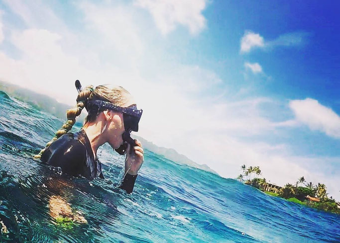Scuba diver at the surface with her hair in a tied ponytail 