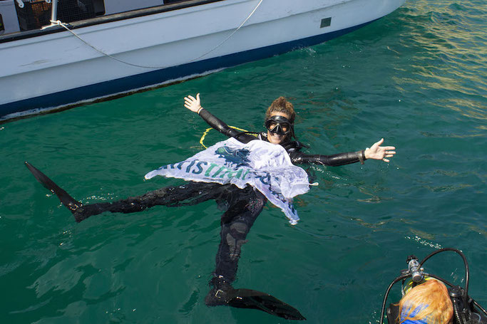 A scuba diver floating at the surface with a Girls that Scuba flag on an Advanced Open Water course.