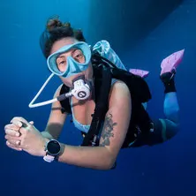 Scuba diver wearing a black and silver Suunto D5 dive computer with a pink strap