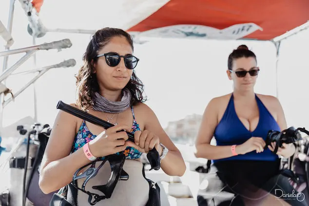 Scuba divers preparing their dive equipment on the boat