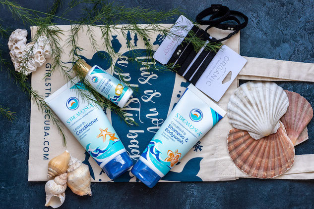 Sustainable gift of Stream 2 Sea skin and hair care laid out with a reusable tote, plastic free hairbands and styled with shells and foliage