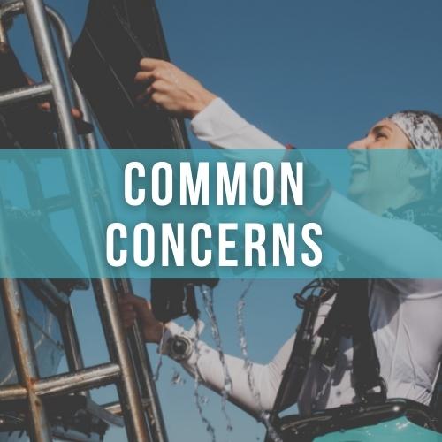 Woman scuba diver smiles as she climbs a ladder and hands up a pair of black fins, overlaid white text reads "COMMON CONCERNS" 