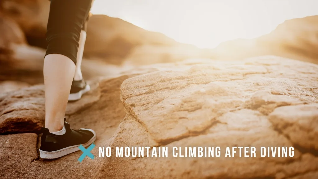 A woman's foot climbing a reddish stone mountain, with clouds in the background. Overlaid white text reads "no mountain climbing after diving", with a teal cross symbol. 