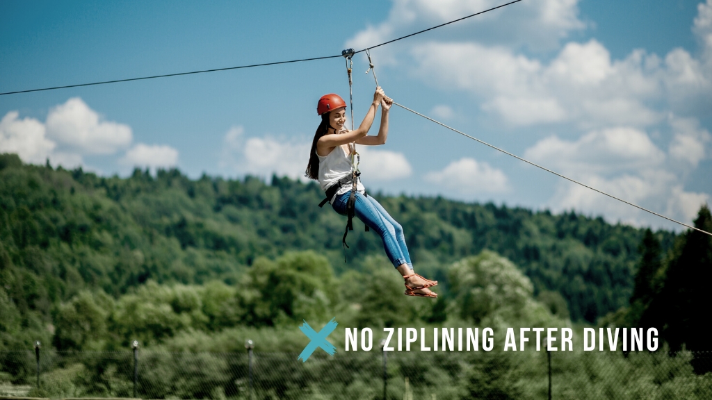 Woman ziplining through lush green forest. Overlaid white text reads "no ziplining after diving" with a teal cross. 