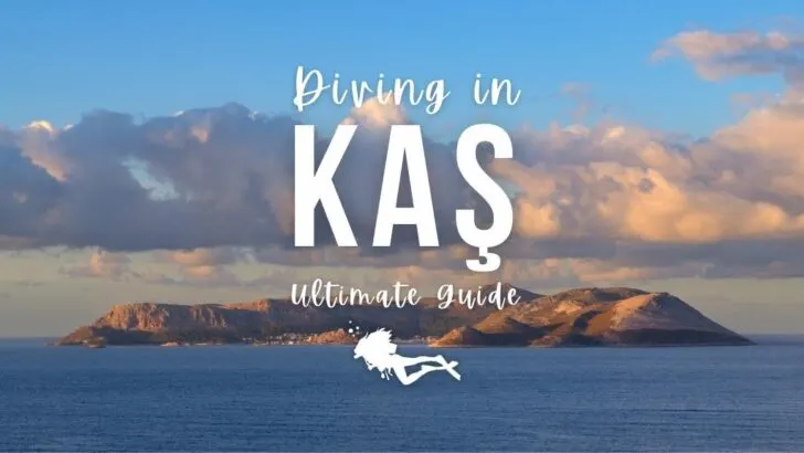 A small island can be seen in deep blue ocean with blue sky off the coast of Kas, Türkiye. Overlaid white text reads "Diving in Kas Ultimate Guide"