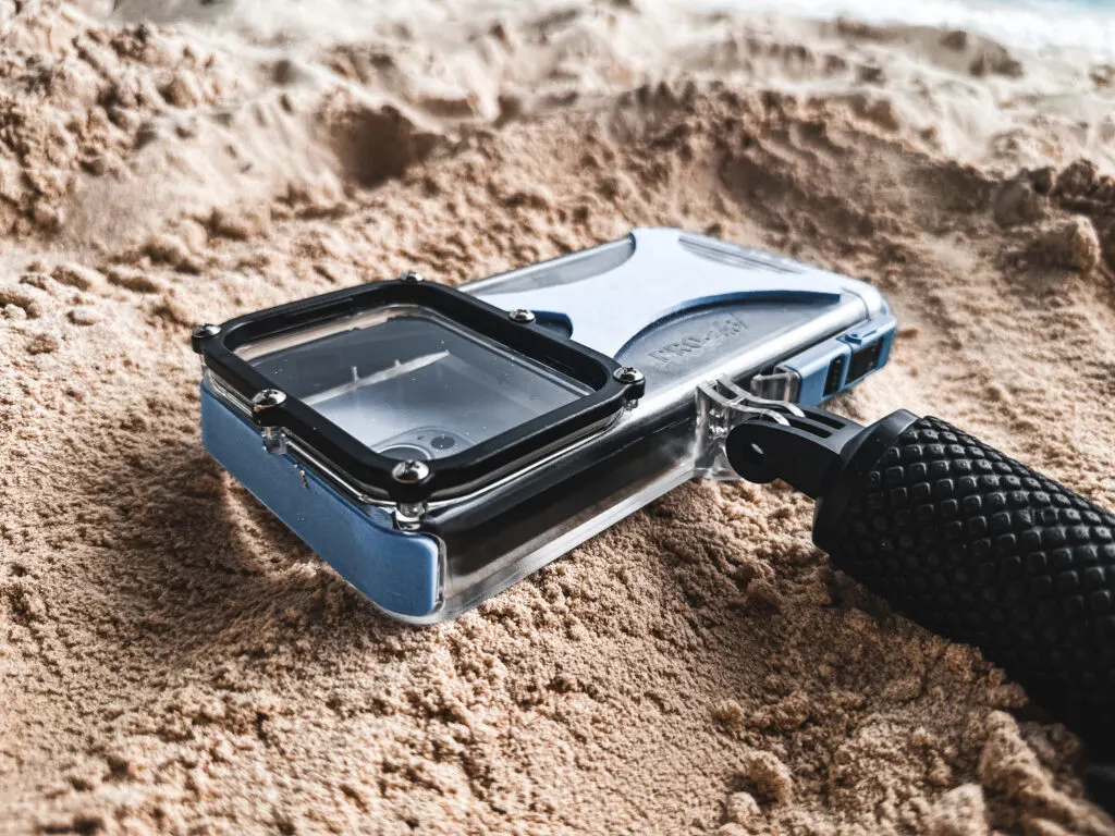 The ProShot Dive Case underwater iPhone housing sits on a sandy background.