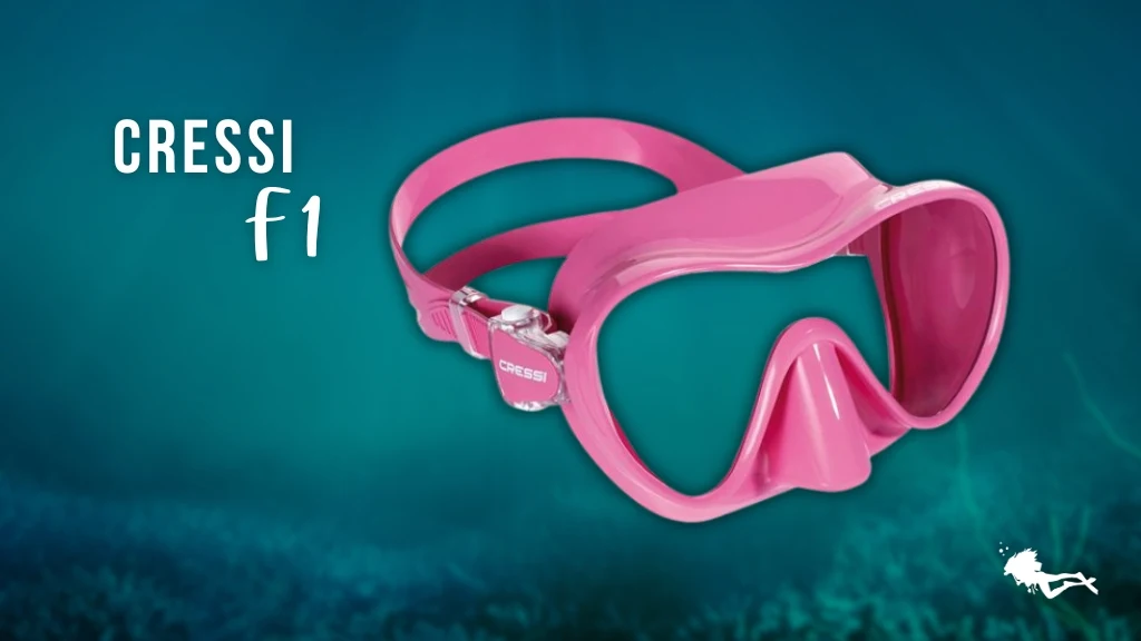 A Cressi F1 women's scuba mask in pink against a blurred ocean background. 